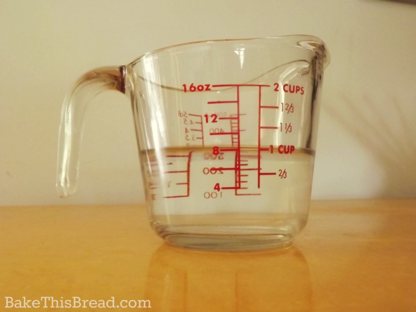 Glass Measuring Cup with 1 cup warm water for homemade yeast bread by bake this bread