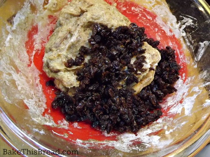 Hand mixing raisins into yeast cinnamon dough recipe by bakethisbread