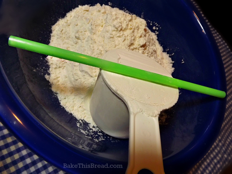 Measuring fluffy bread flour for cinnamon bread using a plastic straw by bake this bread